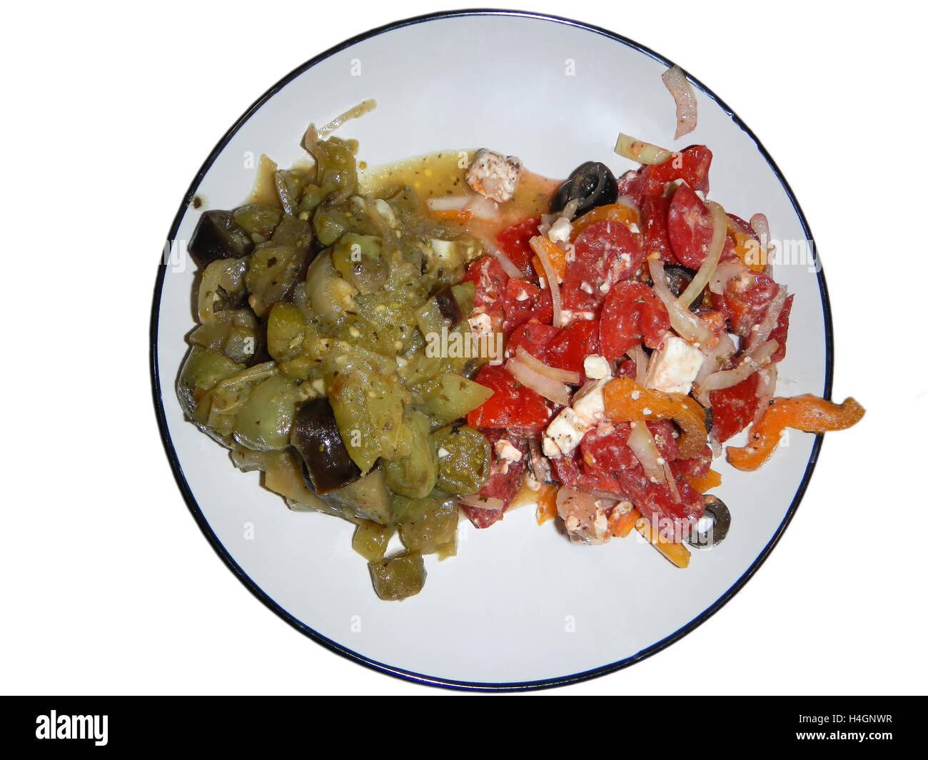 Compotée de tomates vertes avec oignon blanc sur le tour de lave près de salade multicolore avec du fromage feta, tomates rouges, oignon blanc Banque D'Images
