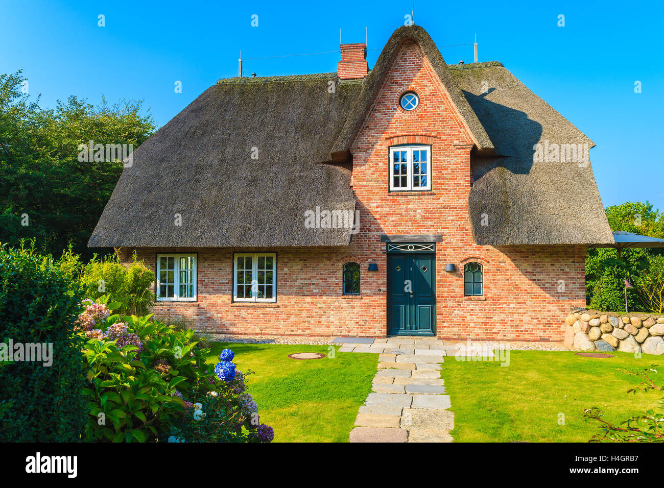 L'île de Sylt, ALLEMAGNE - SEP 9, 2016 : le frison typique maison en brique rouge avec toit de paille à Kampen village sur l'île de Sylt, Allemagne. Banque D'Images