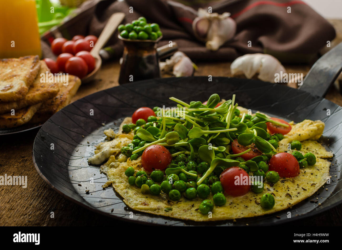 Omelette aux légumes sains - pois et tournesol microgreens, tomates cerises rôties Banque D'Images