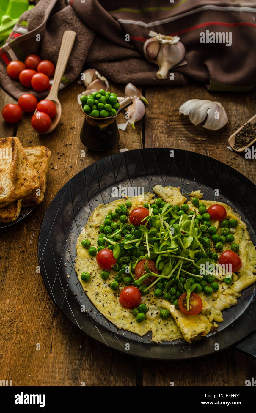 Omelette aux légumes sains - pois et tournesol microgreens, tomates cerises rôties Banque D'Images