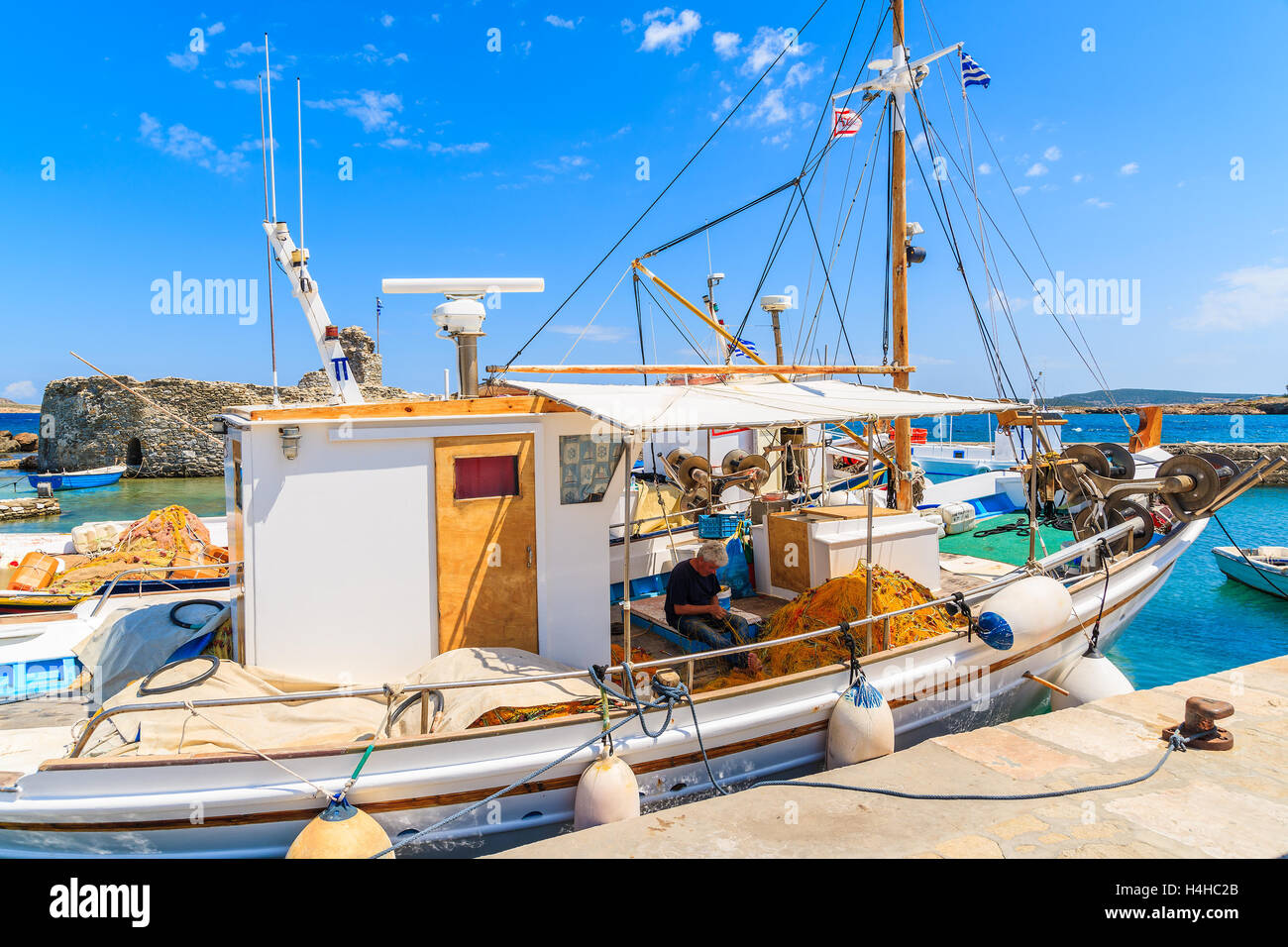 PORT DE NAOUSSA, PAROS ISLAND - 18 MAI 2016 : pêcheur travaillant sur un bateau dans le port de Naoussa sur journée ensoleillée, l'île de Paros, Cyclades, Gre Banque D'Images