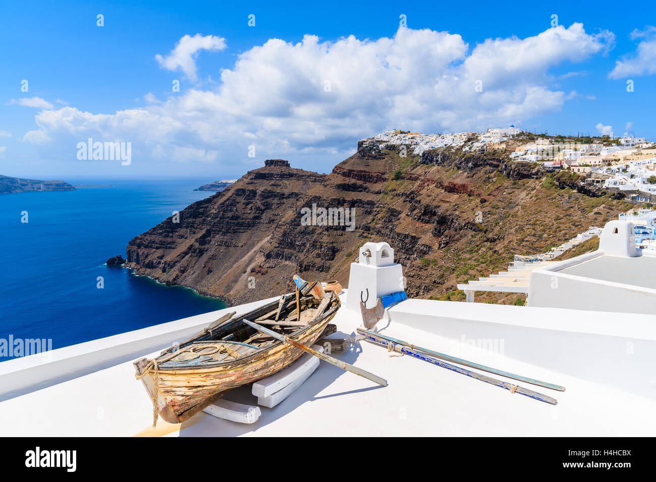 Vieux bateau en bois sur le toit d'une maison dans un beau village de Firostefani avec blanc typique de l'architecture, l'île de Santorin, Grèce Banque D'Images