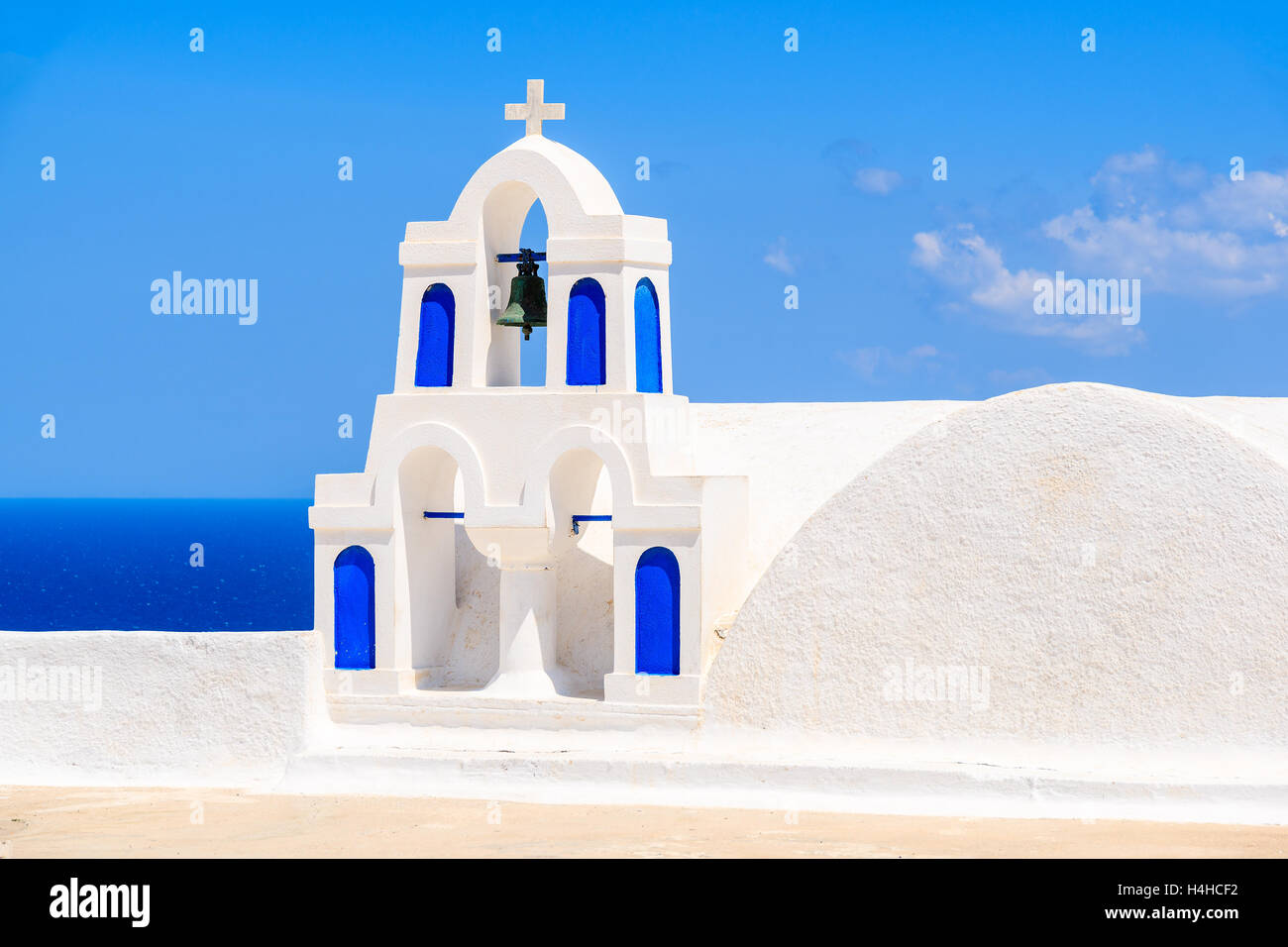 Blanc typique de l'église grecque contre la mer bleue en arrière-plan le village d''Oia sur l'île de Santorin, Grèce Banque D'Images
