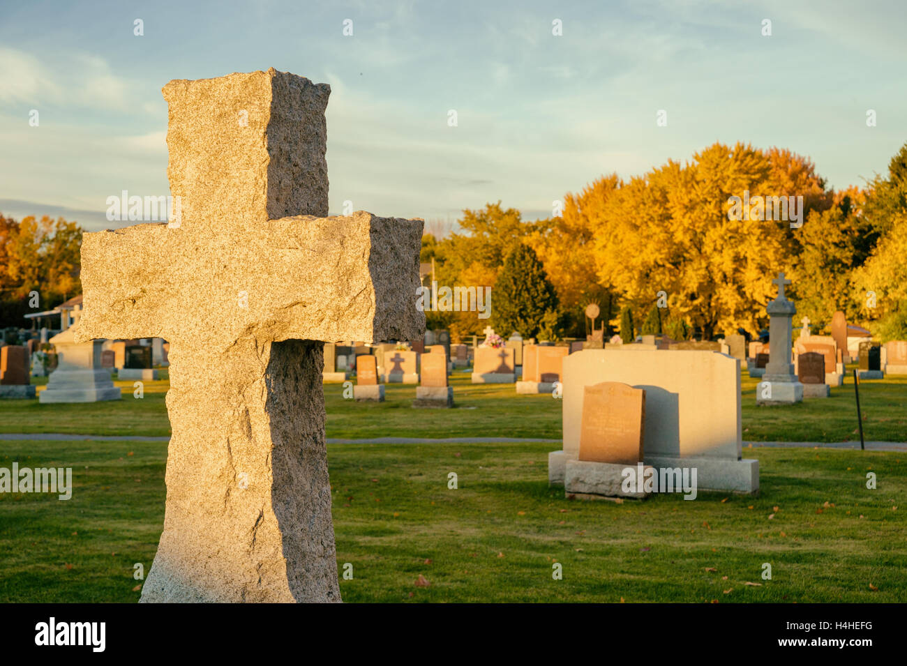 Croix dans un cimetière avec grands érables dans l'arrière-plan, à l'automne (Beloeil, Québec, Canada) Banque D'Images