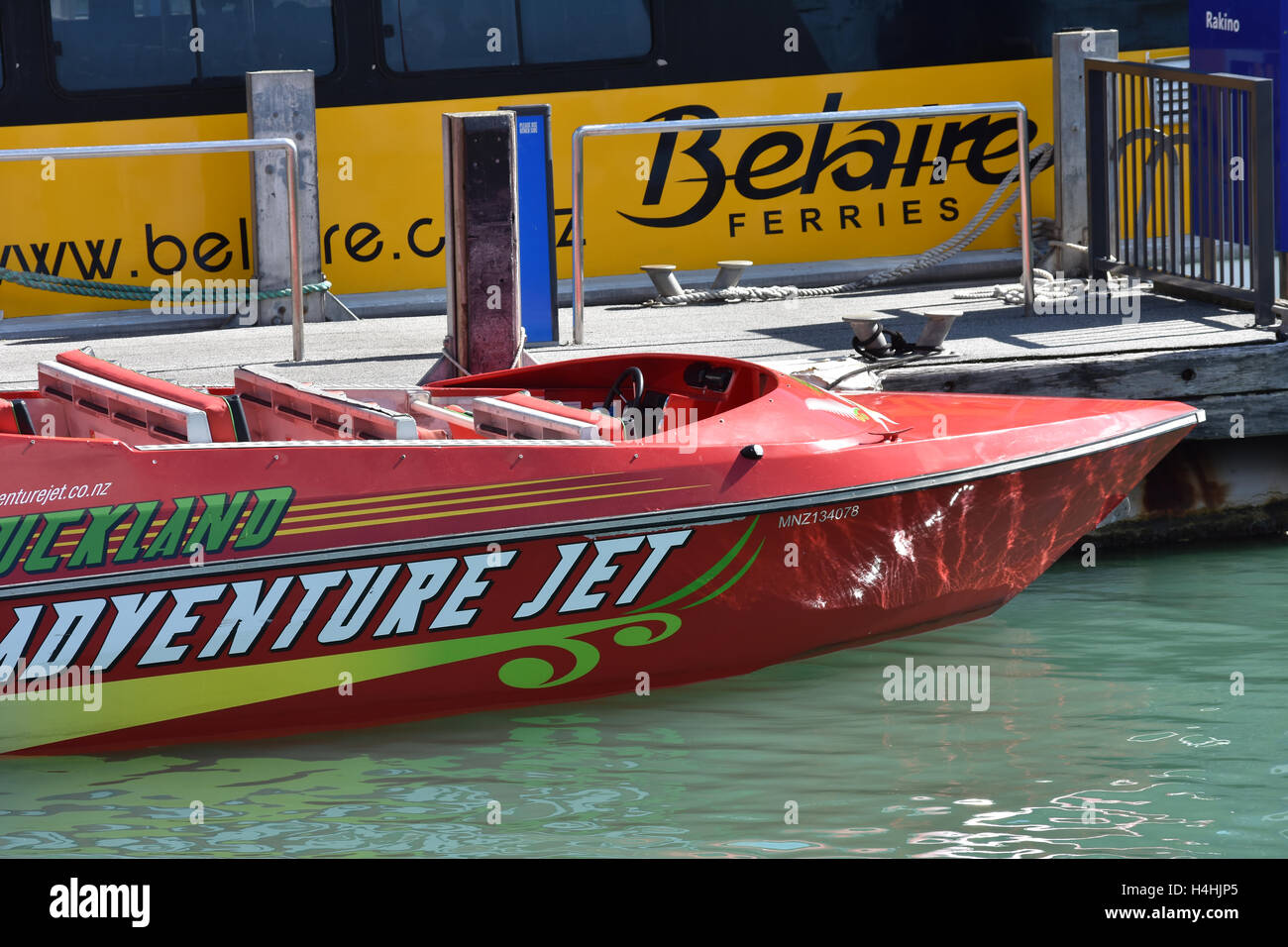 Jet d'eau rouge powered by speed boat accostera au quai dans le centre-ville d'Auckland. Banque D'Images