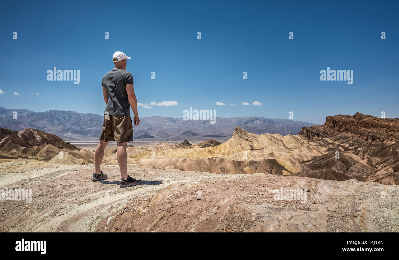 Randonneur debout sur le rebord de Zabriskie point dans la région de Death Valley National Park en Californie Banque D'Images