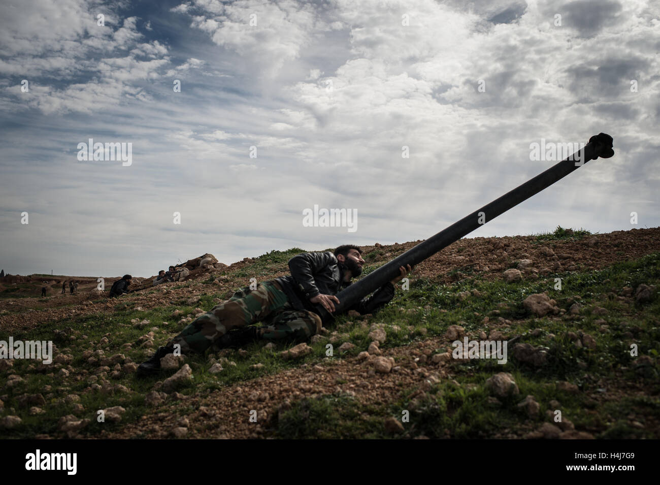 Astuce anti-sniper - 14/02/2013 - Syrie / Alep / Al-Bab - un combattant de la brigade d'Abo Baker ( l'Armée syrienne libre) avec un tube de métal l'illusion force gouvernementales tireurs d'entre-temps ses camarades sont tirer sur les positions ennemies au cours de combats contre les troupes syriennes govenmental Kwiriss la défense de l'aéroport militaire, dans Al-Bab près d'Alep. - Edouard Elias / le Pictorium Banque D'Images