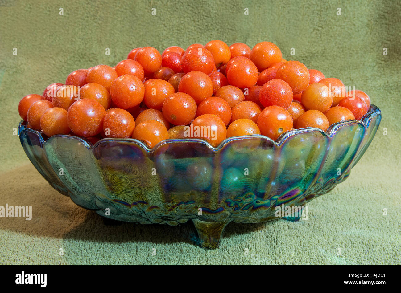 Grande quantité de tomates cerises dans un bol en verre décoratif Banque D'Images