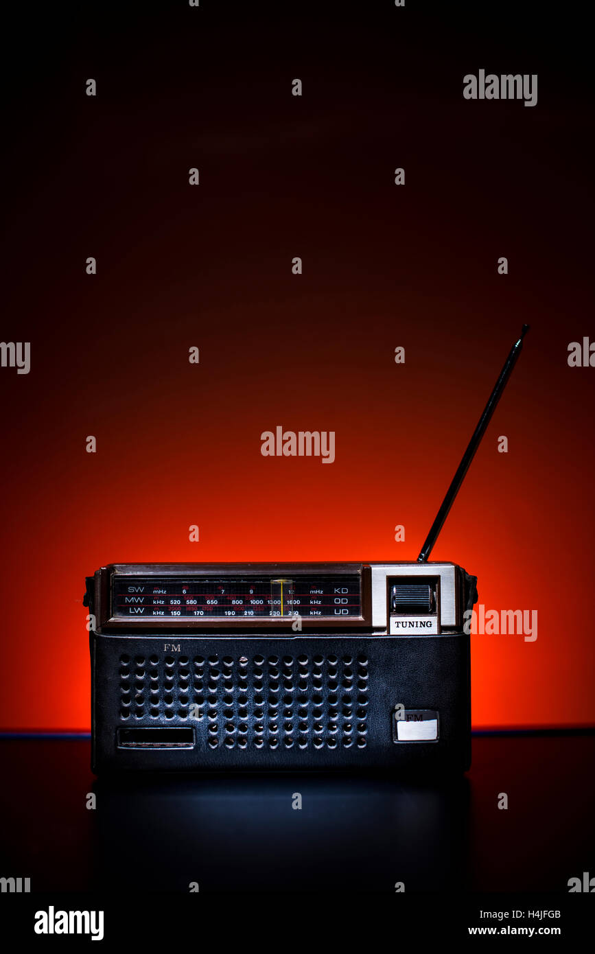Brown a l'ancienne radio dans un étui en cuir sur fond rouge. Banque D'Images