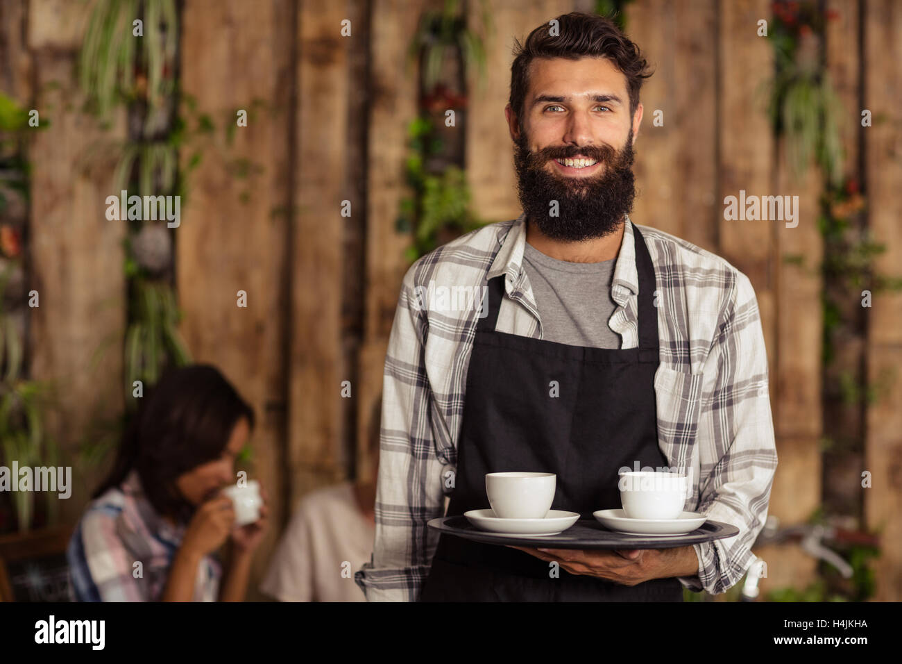 Portrait of waiter holding une tasse de café dans la région de plateau de service Banque D'Images Portrait of waiter holding une tasse de café dans la région de plateau de service Banque D'Images