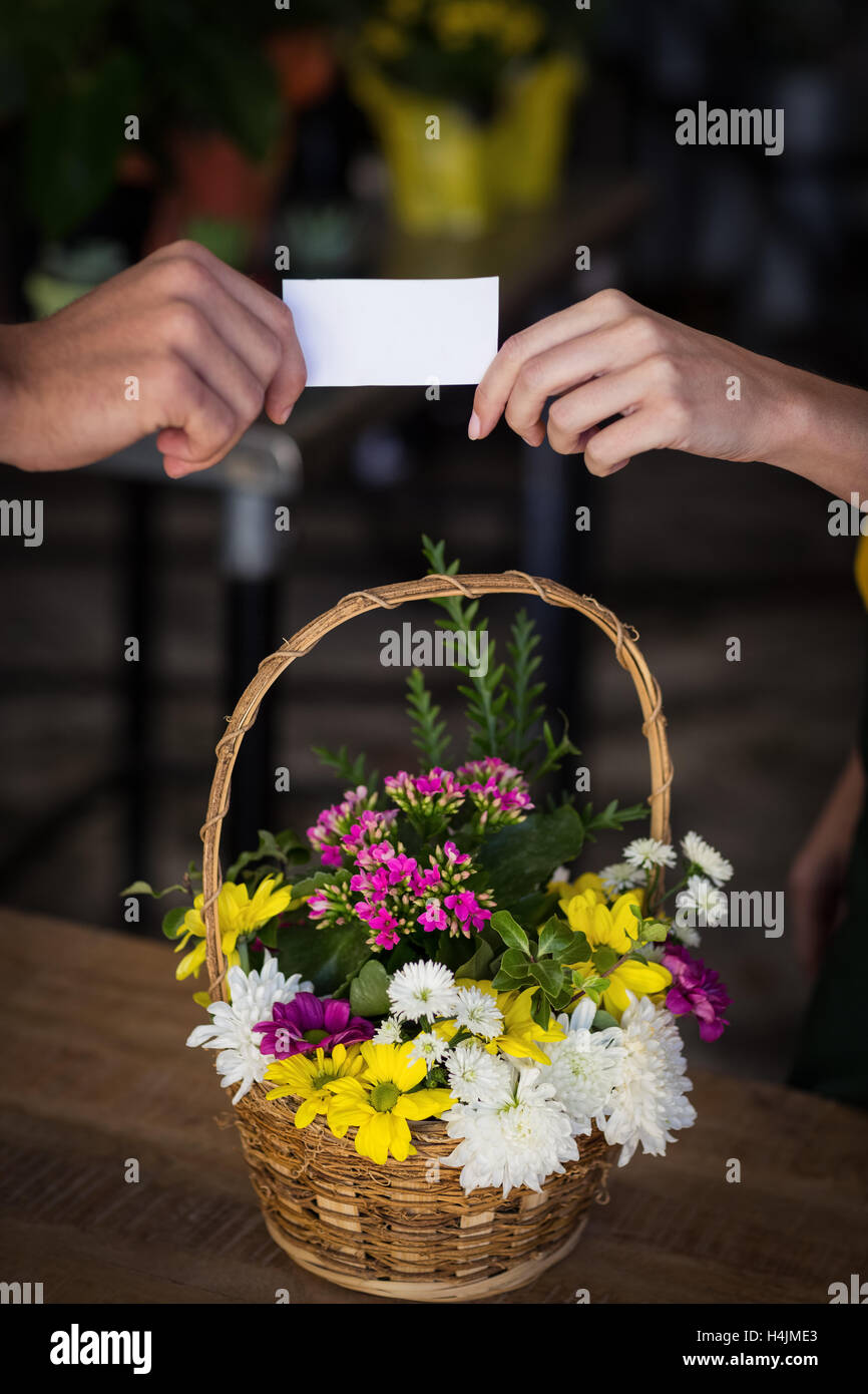 Fleuriste femme carte de visite donnant au client Banque D'Images