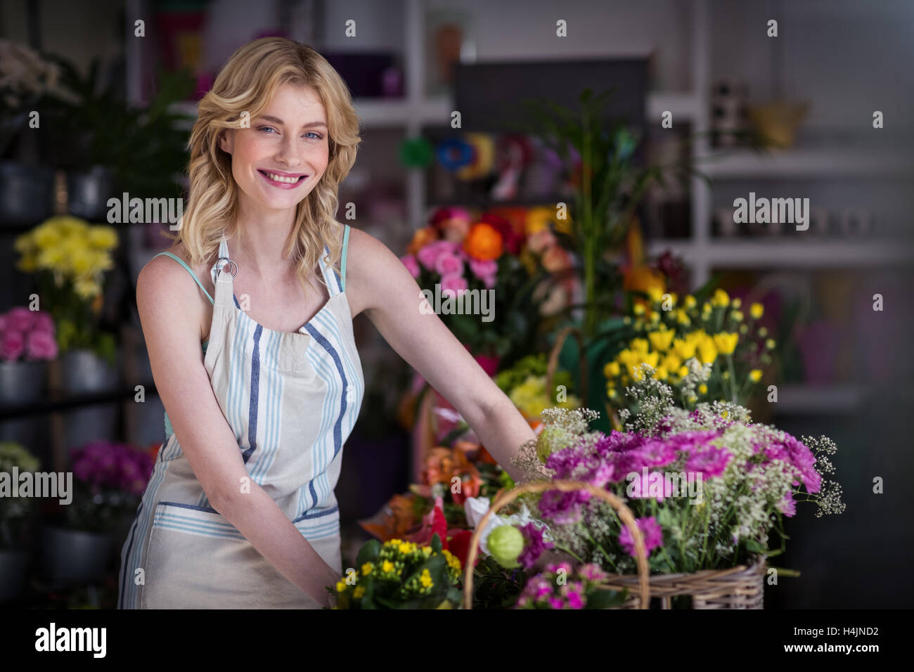 Happy female florist standing in flower shop Banque D'Images