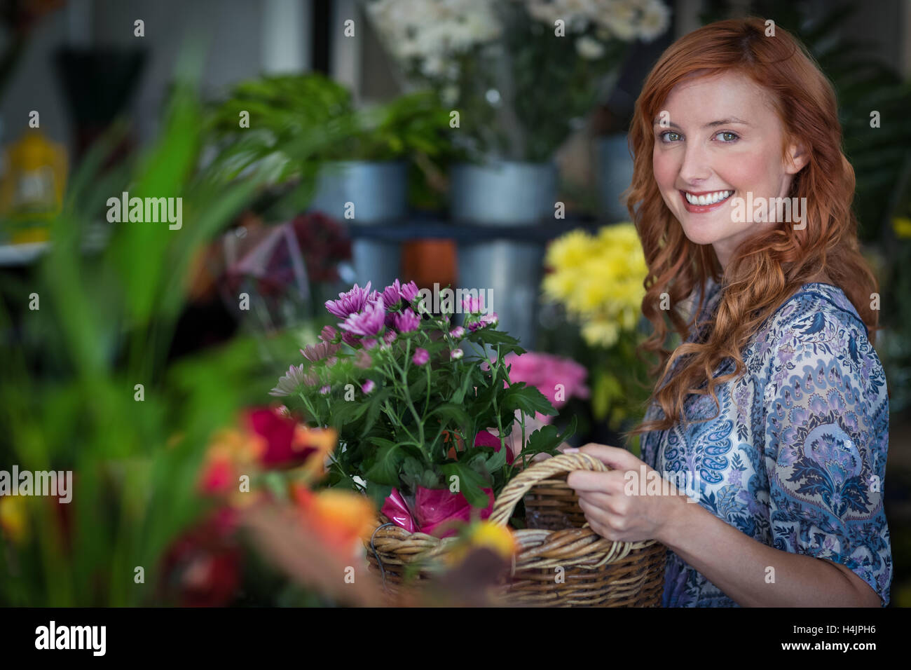 Happy female florist holding panier de fleurs Banque D'Images Happy female florist holding panier de fleurs Banque D'Images