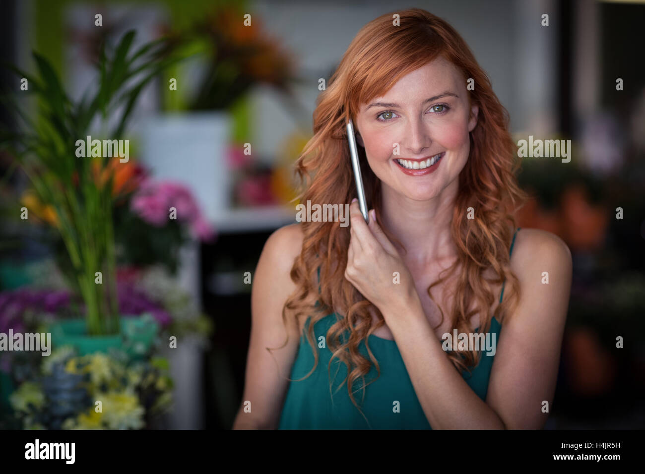 Female florist talking on mobile phone in flower shop Banque D'Images Female florist talking on mobile phone in flower shop Banque D'Images