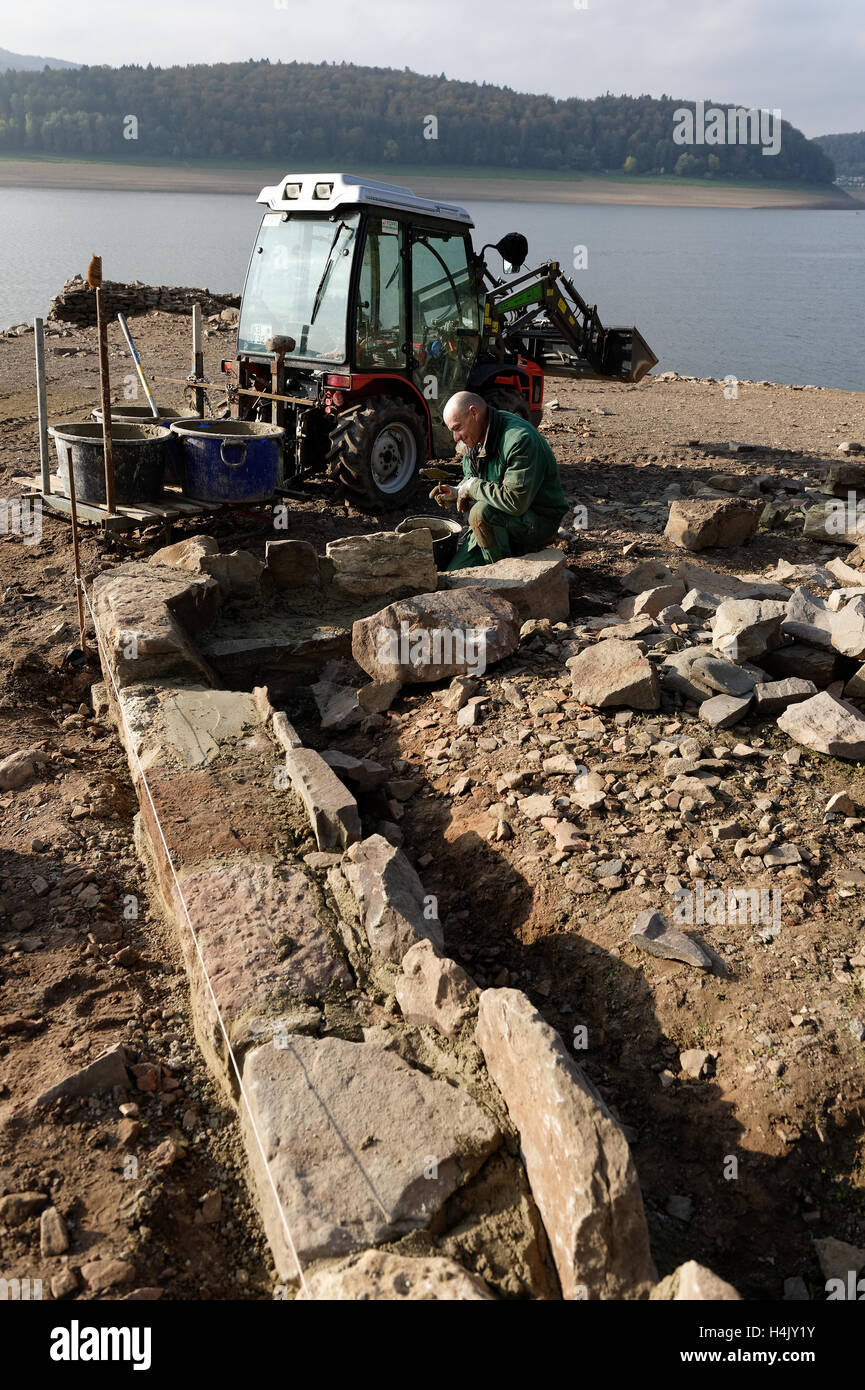Waldeck, Allemagne. 14Th Oct, 2016. Norbert Toffl paysagiste travaille sur les murs de fondation dans la partie village Berich, qui sont sous l'eau à marée haute, peut être vu par le lac Edersee près de Waldeck, Allemagne, 14 octobre 2016. Le village de Berich, qui a été l'accueil de 50 familles, a été rasée en 1913 parce qu'un barrage a dû être créée pour garder le Canal Midland navigable. L'association des amis des plans d Dorfstelle Berich sur la reconstruction des murs de base étape par étape. PHOTO : SWEN PFOERTNER/dpa/Alamy Live News Banque D'Images