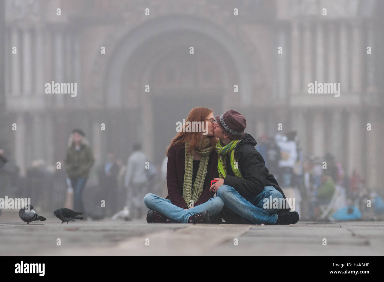 Venise, Italie. 17 octobre, 2016. Un couple de touristes s'embrassent dans le brouillard à la place St Marc à Venise, Italie. L' 'caligo, brouillard typique de Venise, commence en octobre et créer une atmosphère unique à Venise. Credit : Simone Padovani / éveil / Alamy Live News Banque D'Images
