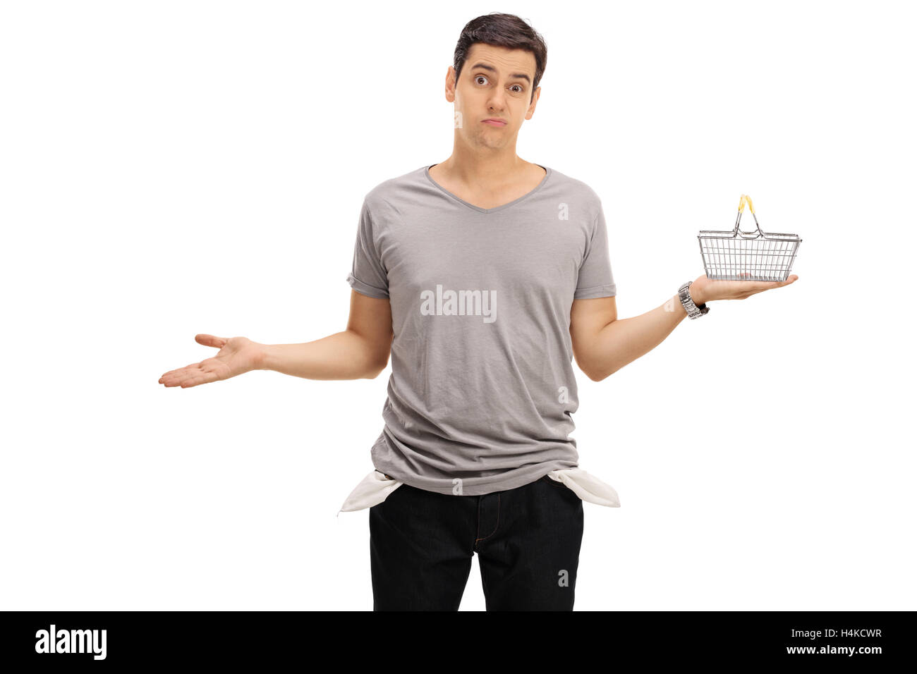 Jeune homme triste montrant ses poches vides et tenant un petit panier vide isolé sur fond blanc Banque D'Images