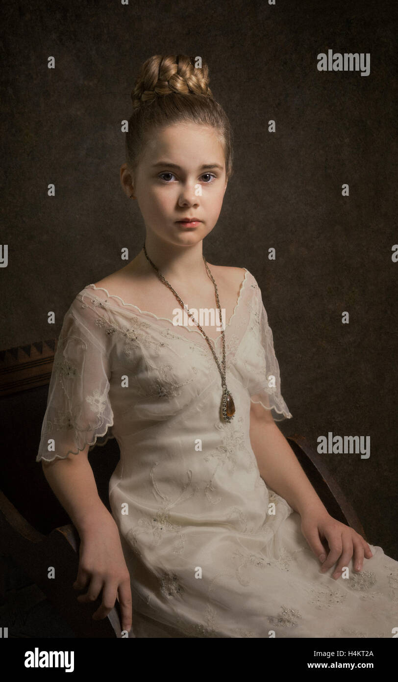 Portrait d'une jeune fille assise sur une chaise Banque D'Images
