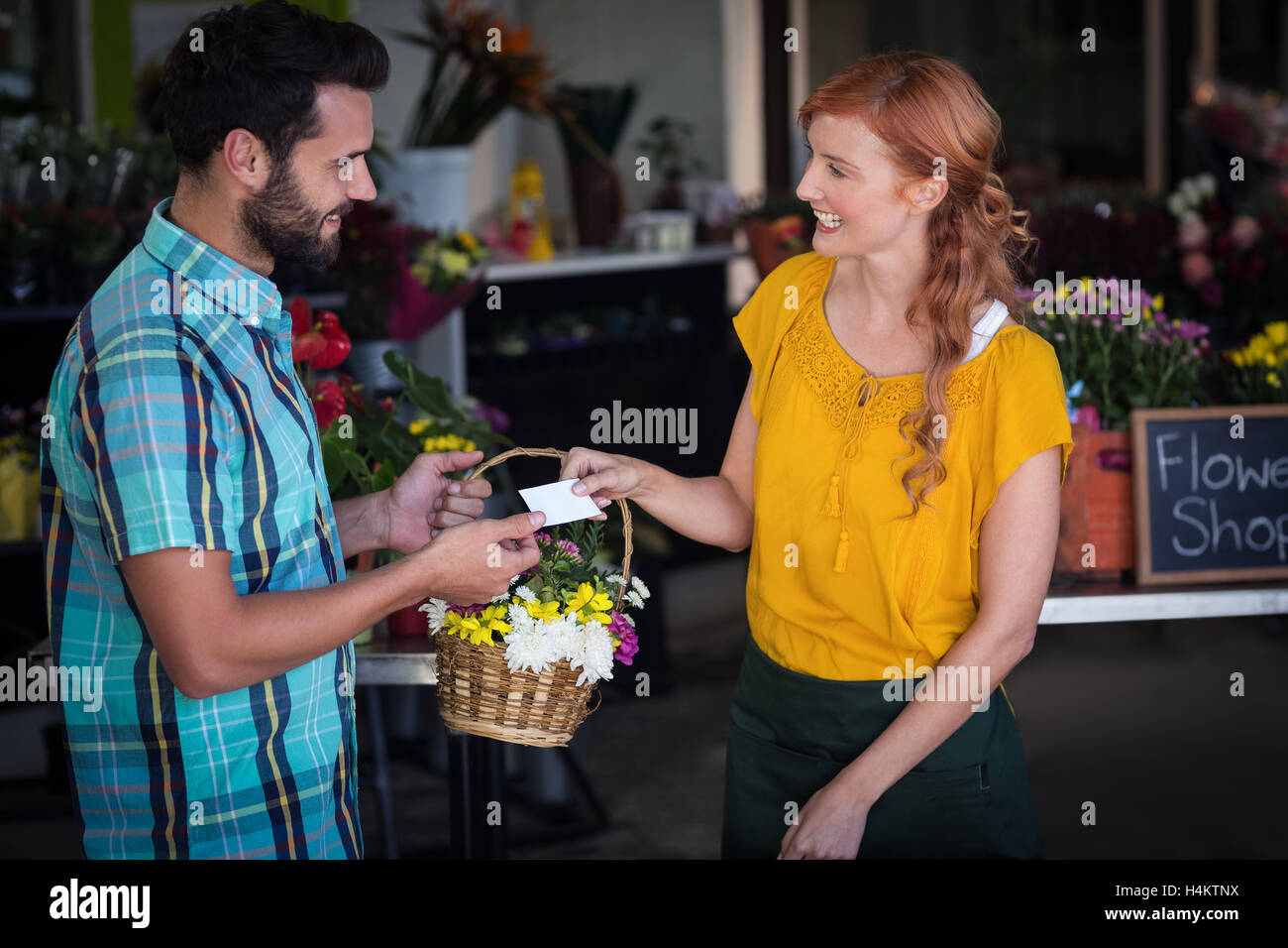 Carte de visite donnant owner et panier de fleurs au client Banque D'Images