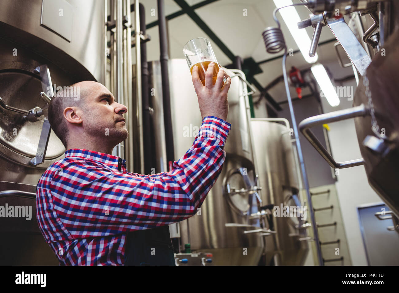 L'inspection de travailleur de la bière dans des contenants de verre Banque D'Images