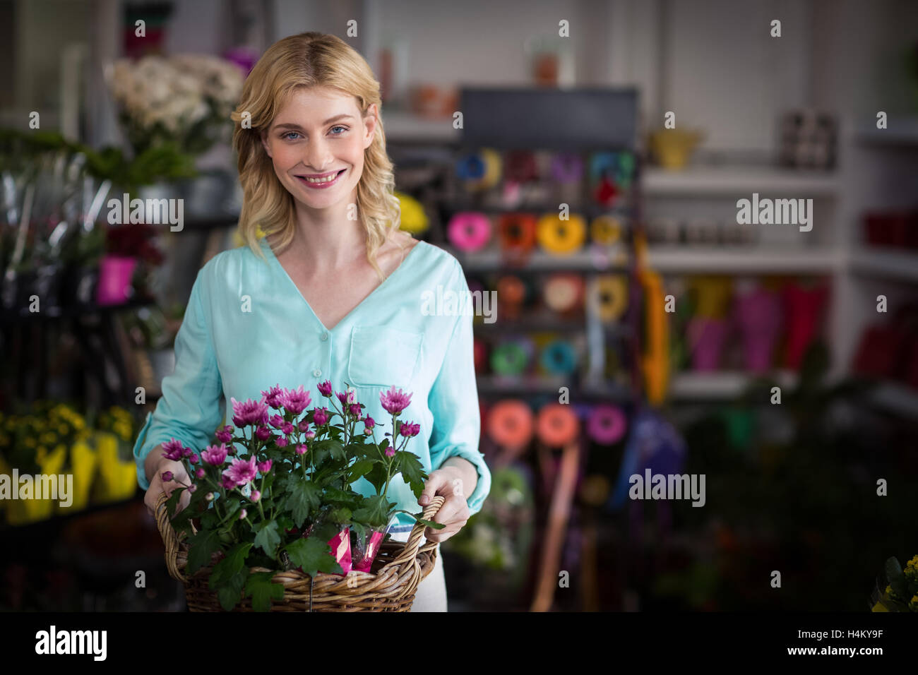 Happy female florist holding panier de fleurs Banque D'Images