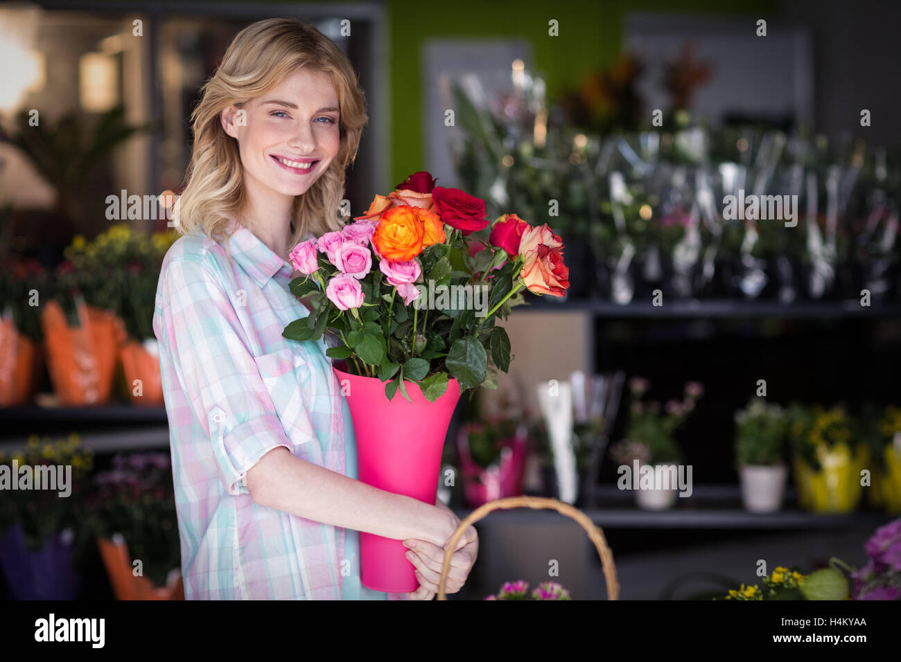 Happy female florist holding flower vase Banque D'Images