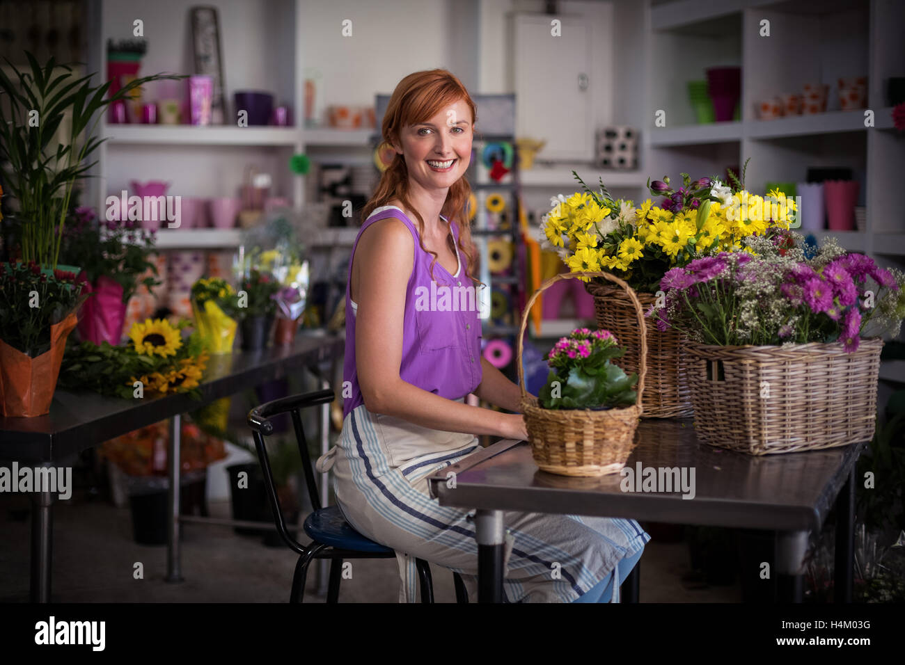 Fleuriste femme assise avec panier de fleurs Banque D'Images