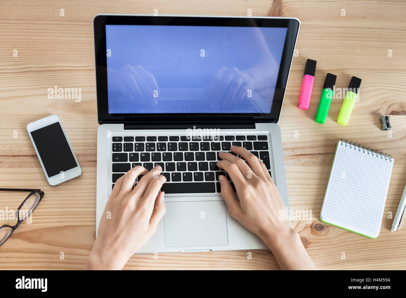 Top-view of woman using laptop on bureau en bois Banque D'Images