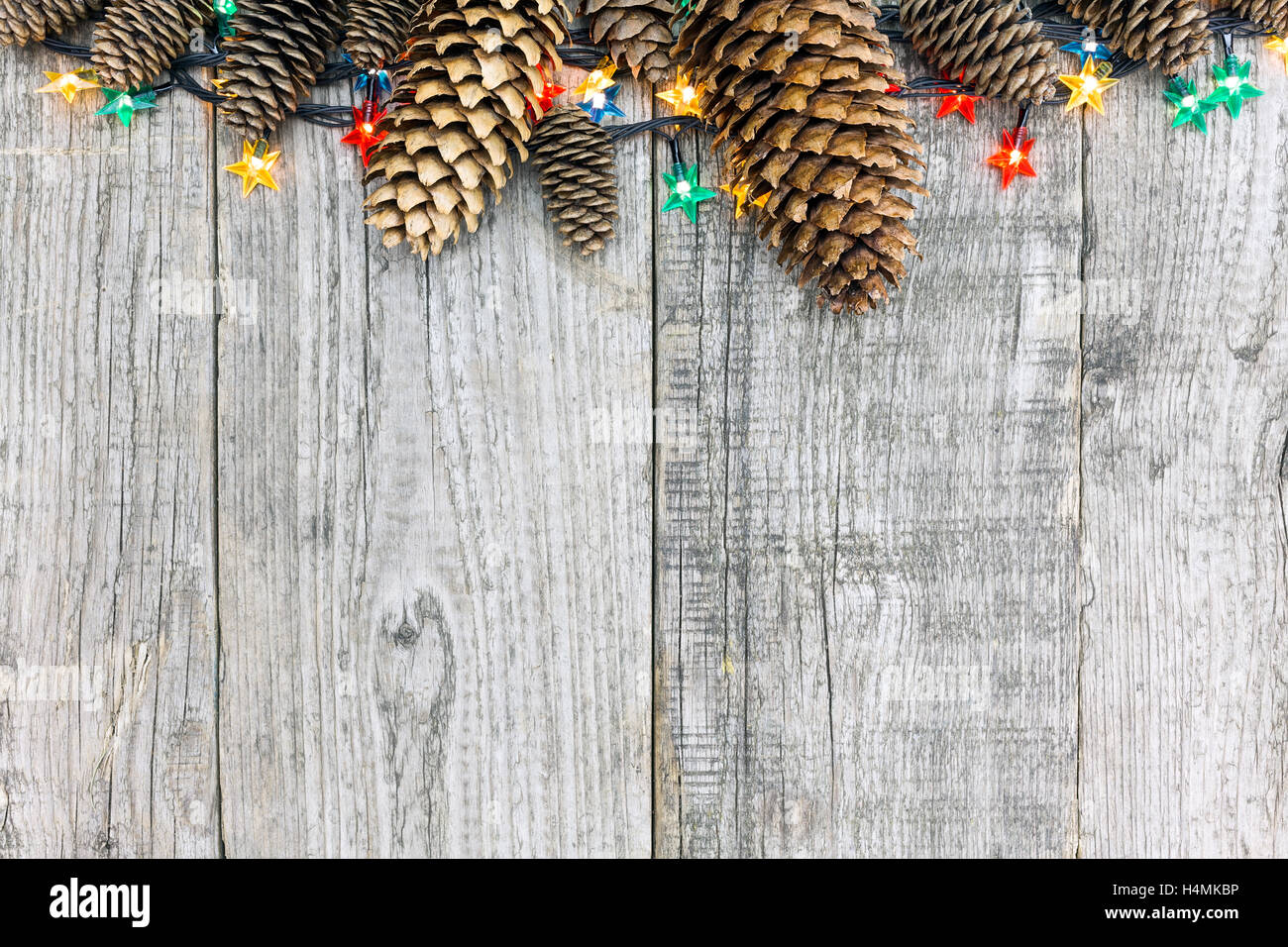 Décoration de Noël avec des pommes de pins et de lumières sur fond de bois naturel Banque D'Images