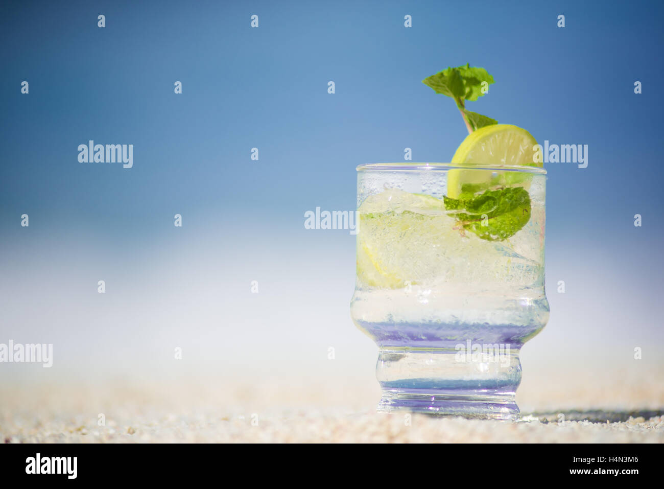 Un verre de limonade sur plage de sable Banque D'Images