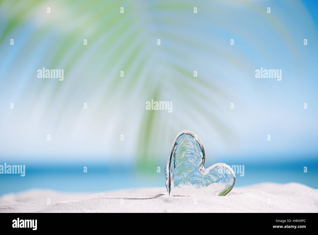 Coeur de verre clair sur une plage de sable blanc, océan, ciel et seascape Banque D'Images