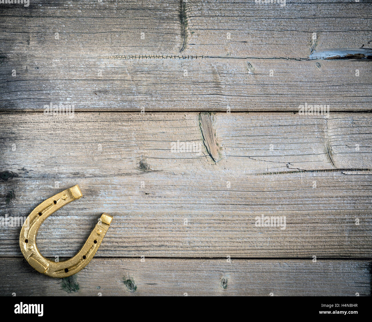Golden horseshoe on a wooden background Banque D'Images