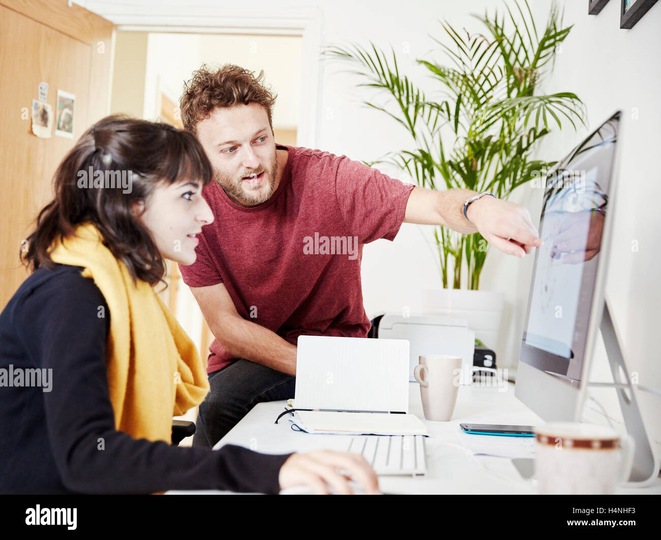 Deux personnes travaillant ensemble au pouvoir, regarder un écran d'ordinateur. Banque D'Images
