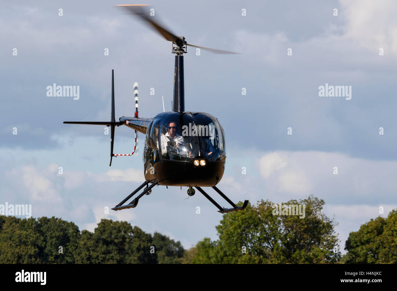 Robinson R44 Raven II G-DKNY atterrissage à Breighton Airfield Banque D'Images