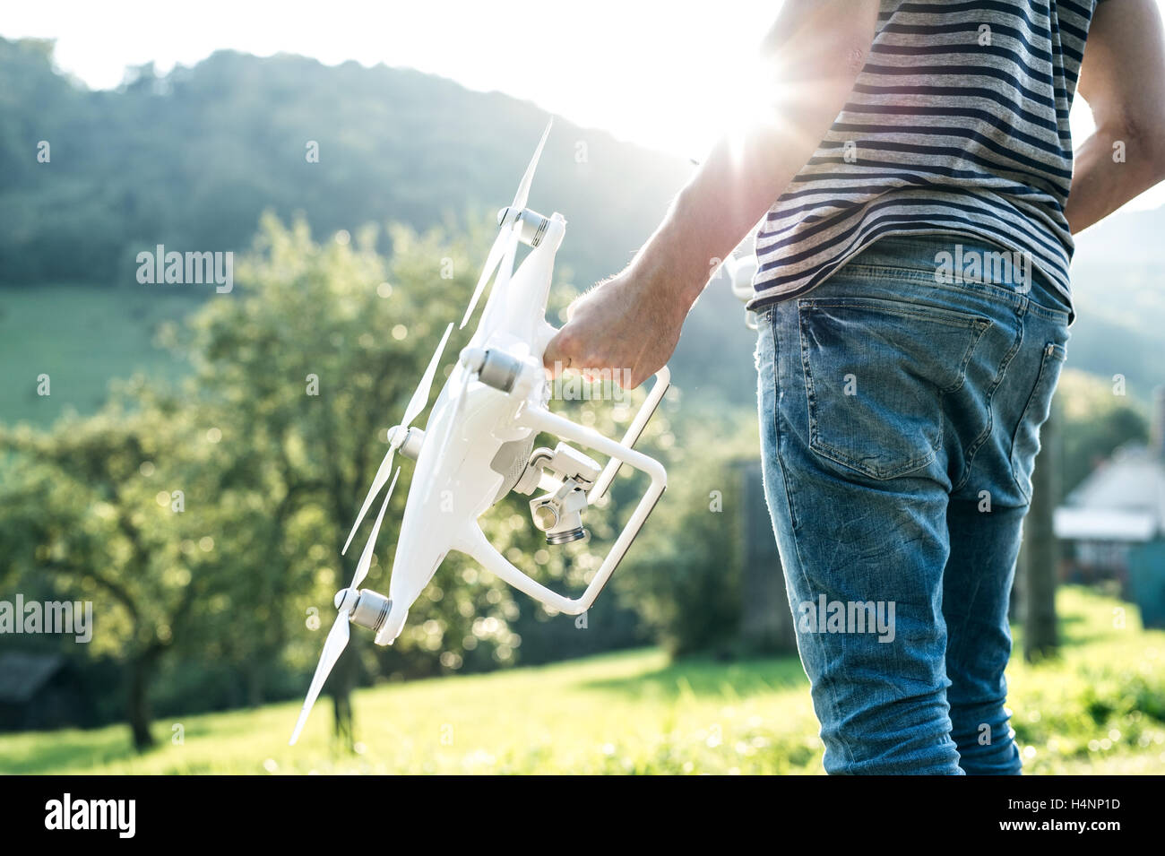Méconnaissable young man holding drone. Vert nature ensoleillée. Banque D'Images