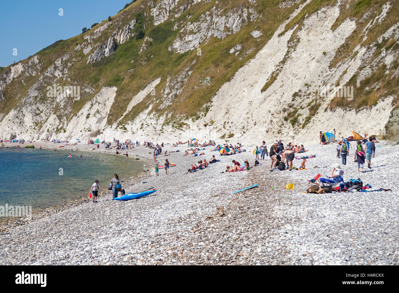 Aux personnes bénéficiant d'une journée ensoleillée à la crique de Lulworth Cove, dans le Dorset, Angleterre Royaume-Uni UK Banque D'Images