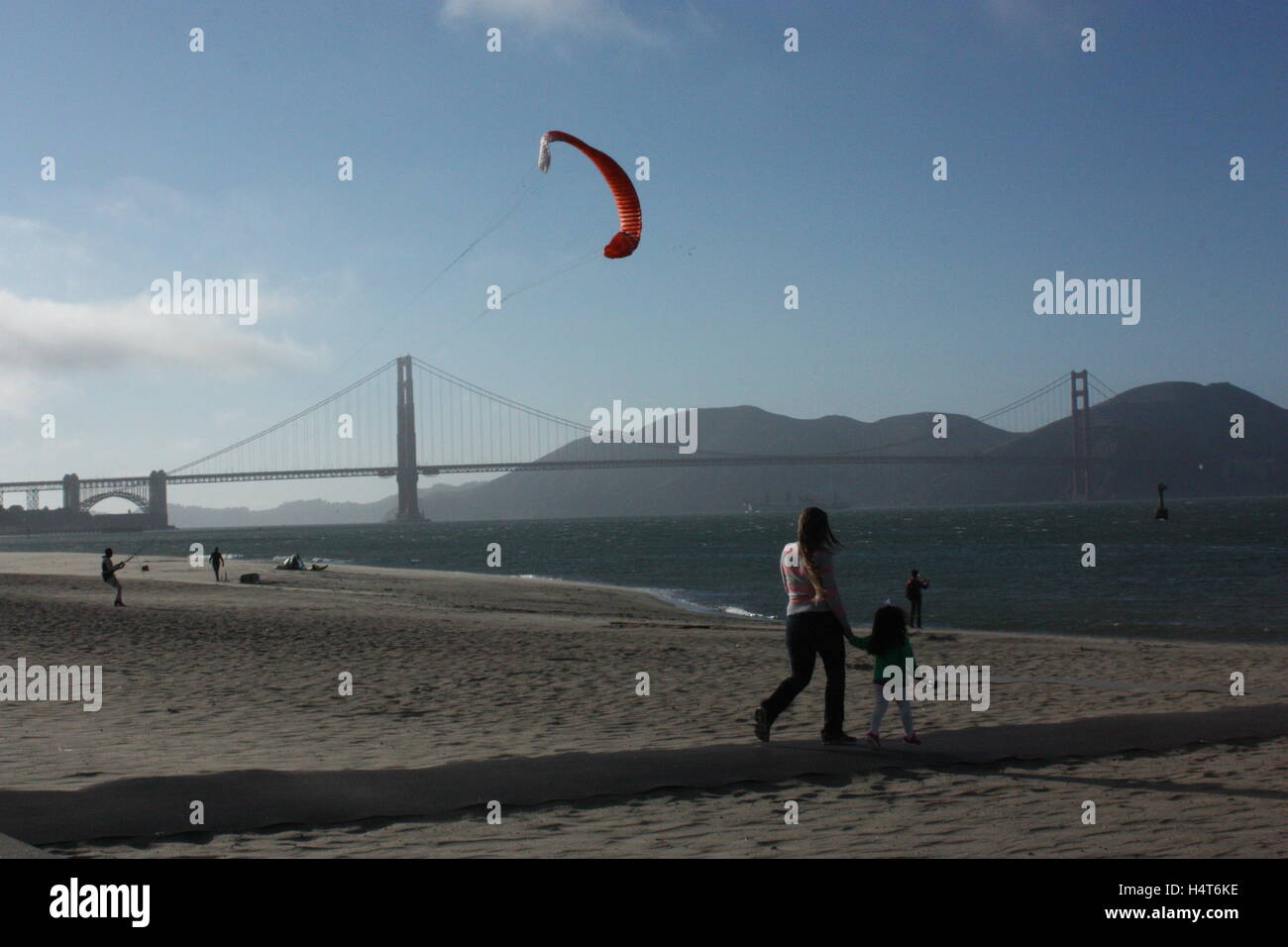 Le Golden Gate Bridge avec quelqu'un voler un cerf-volant sur la plage à côté de la mer Banque D'Images