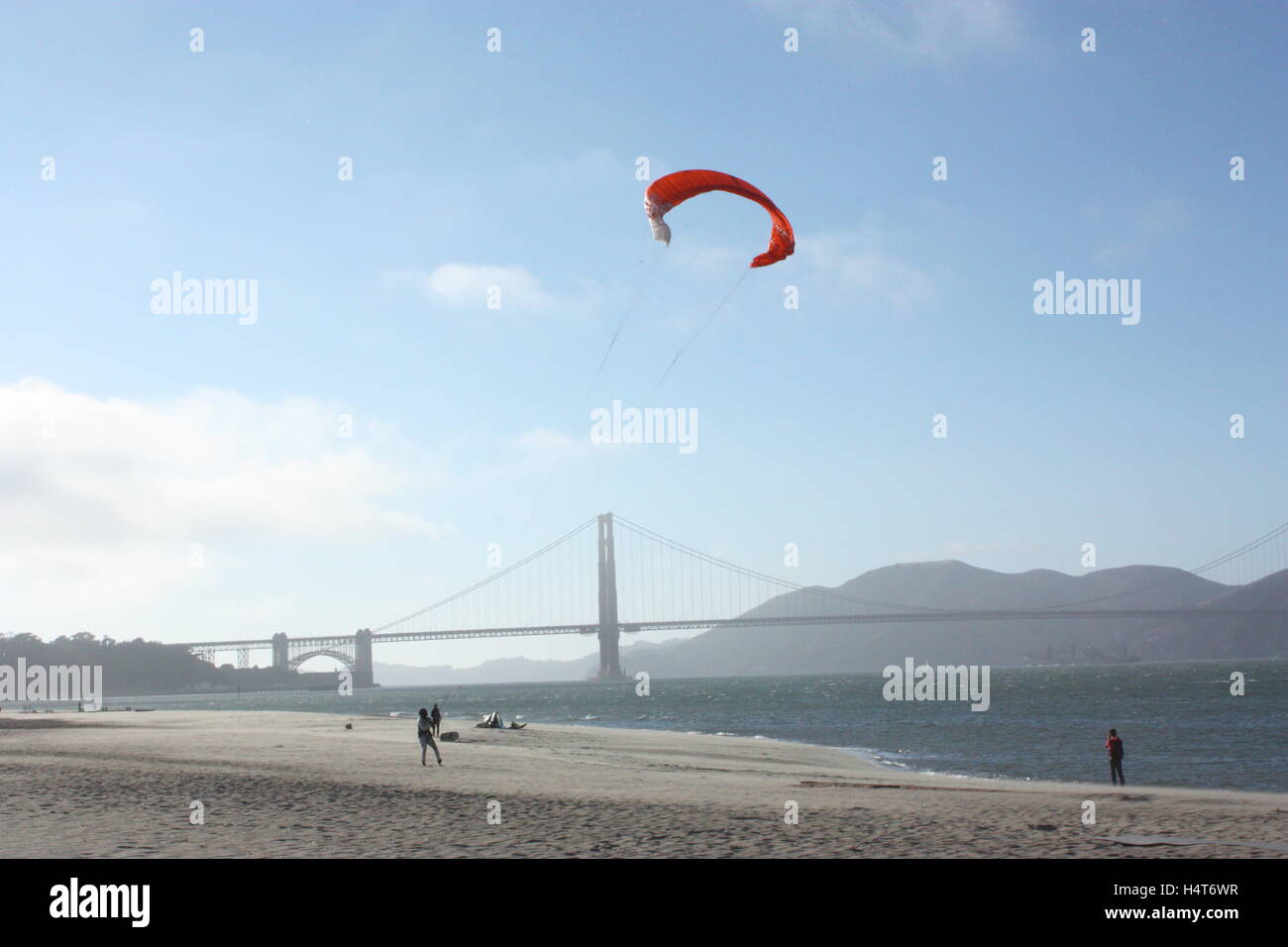 Le Golden Gate Bridge avec quelqu'un voler un cerf-volant sur la plage à côté de la mer Banque D'Images