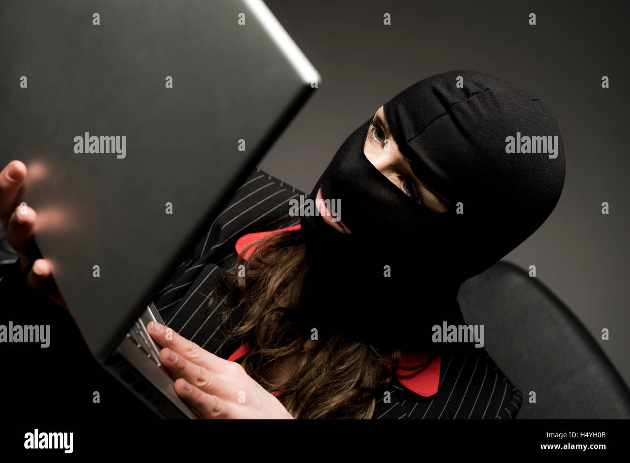 Cambrioleur masqué avec ordinateur portable, l'espionnage économique, le piratage de données Banque D'Images