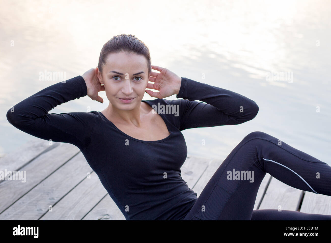 Jolie jeune femme fitness exercices sur pier pendant matin entraînement formation Banque D'Images