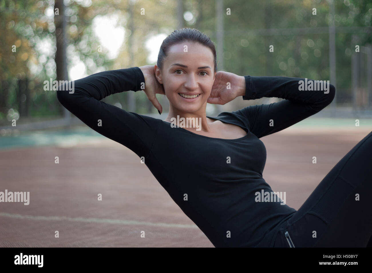 Jolie jeune femme au cours des exercices de remise en forme formation sport matin entraînement sur aire de jeux Piscine en plein air Banque D'Images