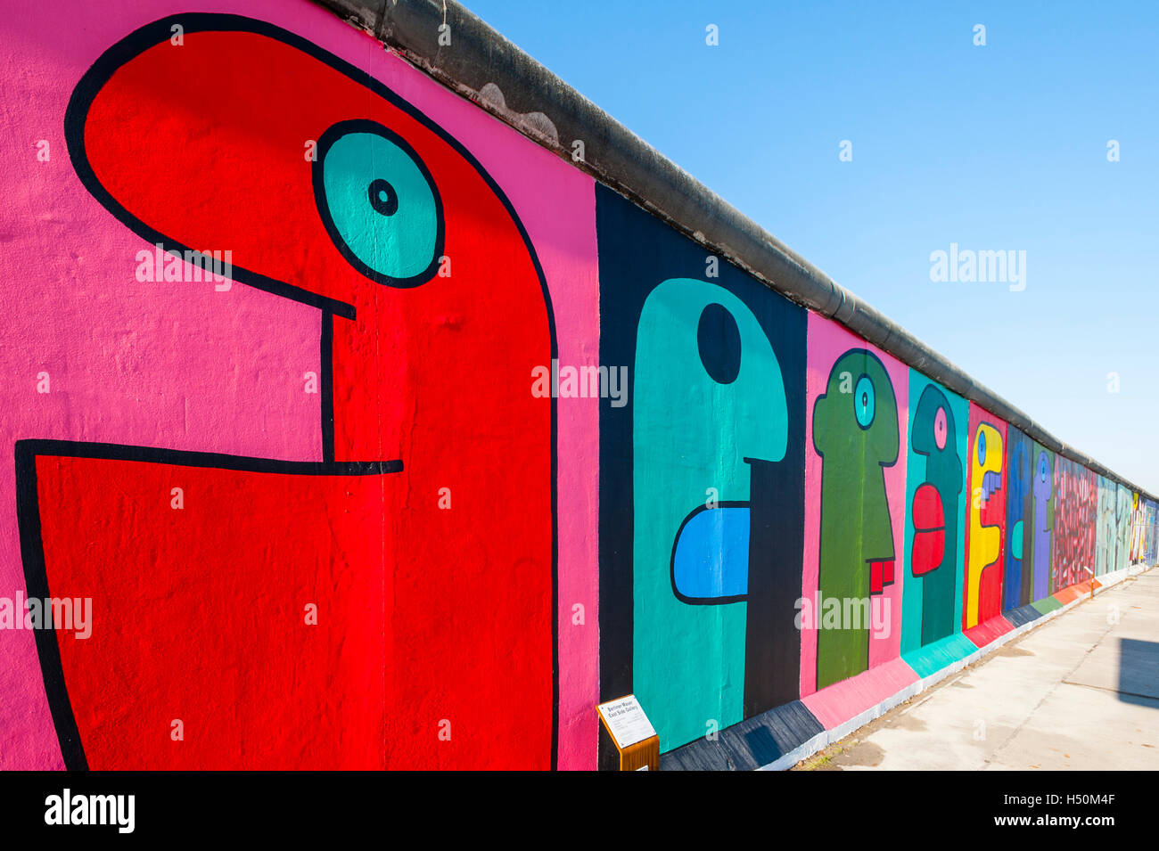 Murales colorées peintes sur mur de la East Side Gallery à l'ancien mur de Berlin Friedrichshain Kreuzberg à Berlin / Allemagne Banque D'Images