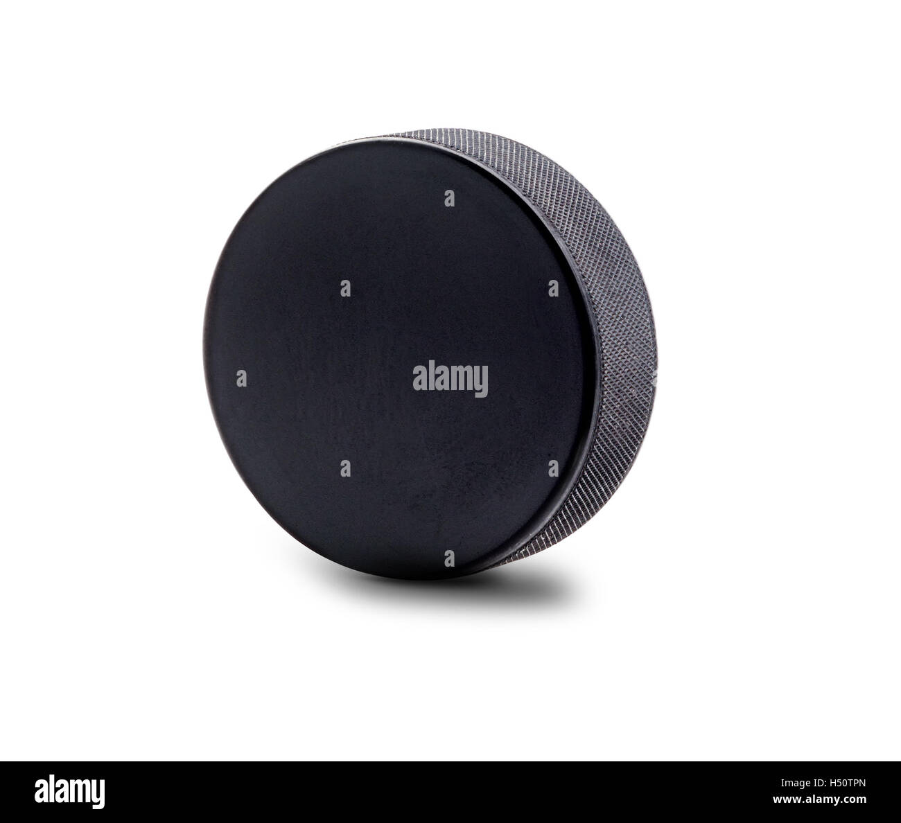 Une rondelle de hockey noir en position verticale isolé sur fond blanc avec l'exemplaire de l'espace. Banque D'Images