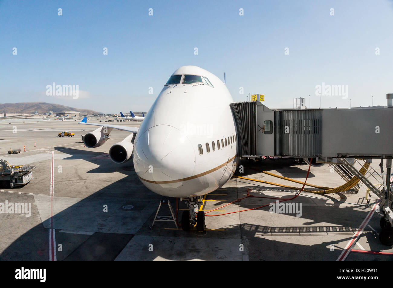 L'accent sur le nez d'un avion de passagers qui est stationné à la porte de l'aéroport et relié à une passerelle. Banque D'Images