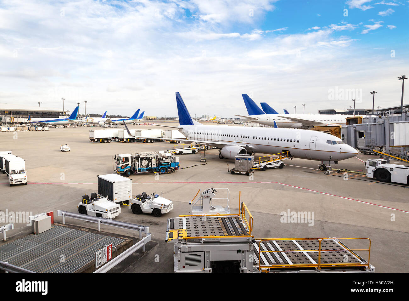 Une flotte d'avions commerciaux en cours d'entretien sur le terminal d'un aéroport international. Banque D'Images