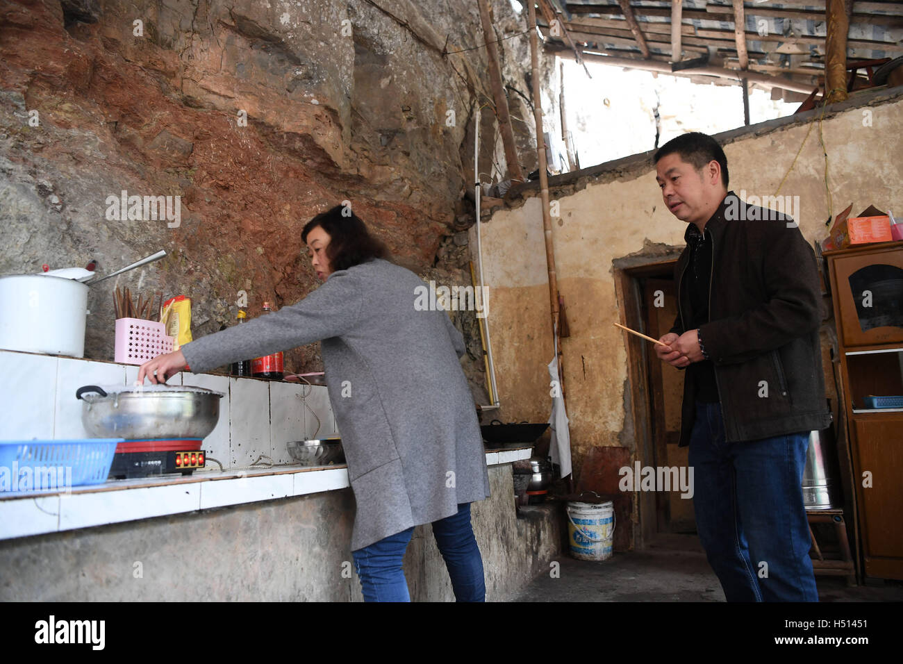 Chongqing, China's Chongqing. 18 Oct, 2016. Liu Jian (R) et la cuisine à la maison Guoqun Li dans l'énorme doline région pittoresque dans le comté de Fengjie, sud-ouest de la Chine, Chongqing, le 18 octobre 2016. Le couple, Liu Jian Li et Guoqun, les résidents seulement ici, sont en charge du nettoyage de la zone panoramique de doline géant depuis 1999. Liu monte les escaliers 2800 pour faire son travail de tous les jours. © Chen Cheng/Xinhua/Alamy Live News Banque D'Images