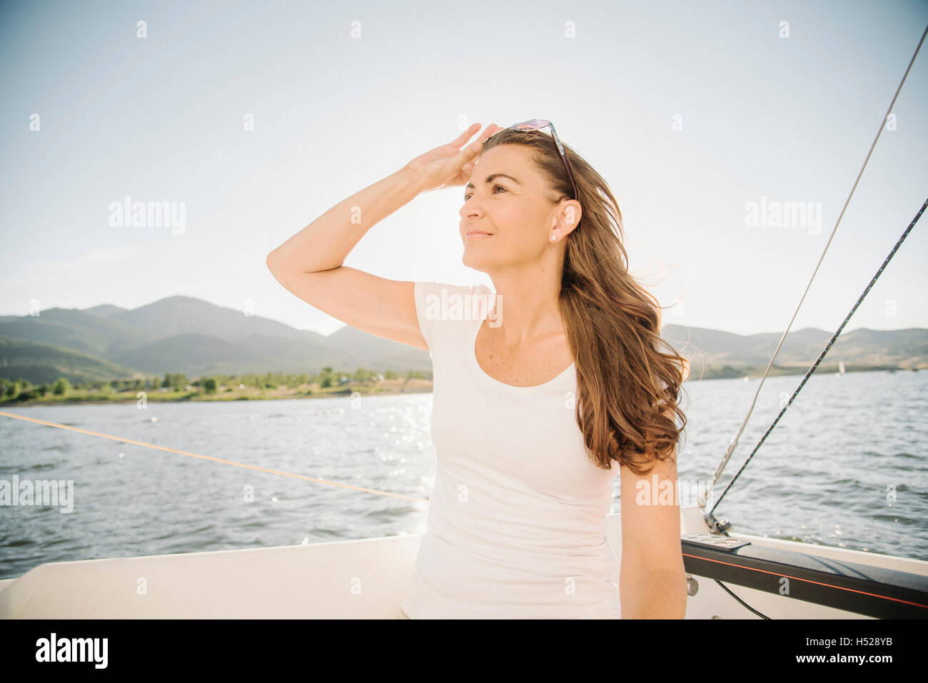 Femme aux longs cheveux bruns sur un voilier. Banque D'Images