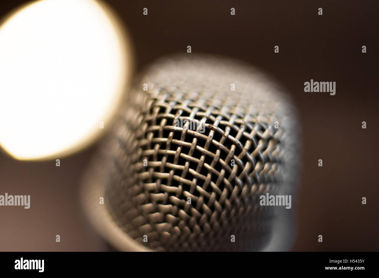 Tête de microphone extreme close up out of focus stage lights en arrière-plan Banque D'Images