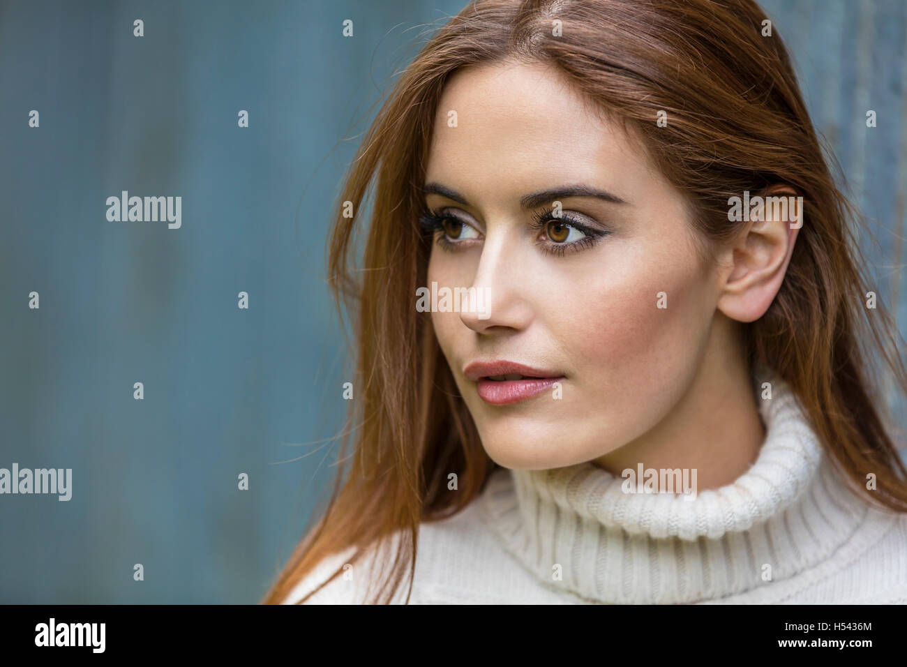 Portrait d'une belle jeune fille ou jeune femme aux cheveux rouges portant un cavalier blanc Banque D'Images