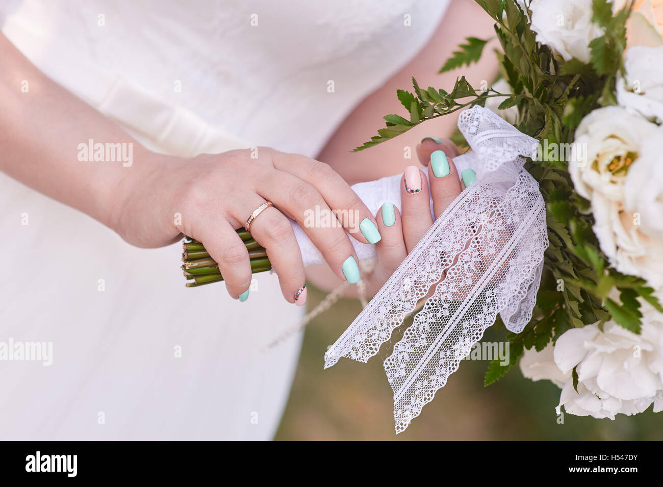 Bride avec anneau main tenant un bouquet de roses blanches Banque D'Images